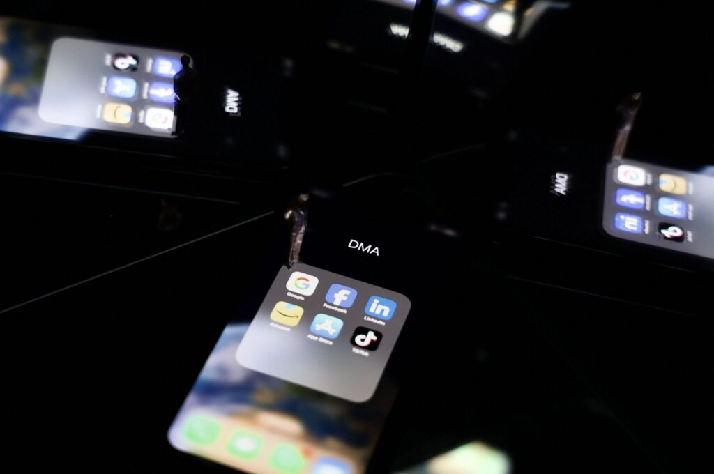 This photo shows reflections on a smartphone screen of logos of online platforms Google, Facebook, LinkedIn, Amazon, Apple store and TikTok, Brussels, Belgium, Feb. 12, 2023. (AFP Photo)