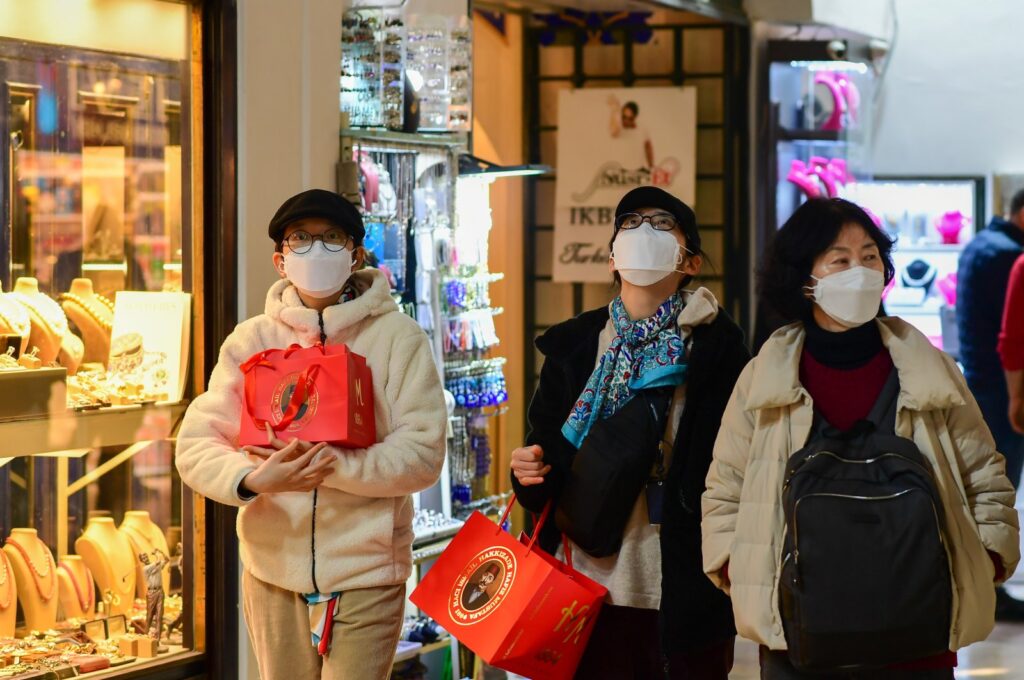 Asian tourists holding shopping bags walk past a jewelry store at the Grand Bazaar, Istanbul, Türkiye, Feb. 28, 2024. (Reuters Photo)