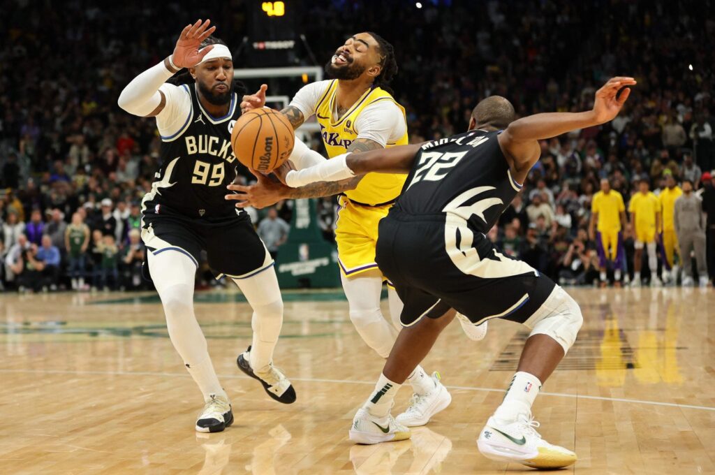 Los Angeles Lakers' D'Angelo Russell (C) is fouled by Milwaukee Bucks' Khris Middleton (R) during overtime at Fiserv Forum, Milwaukee, U.S., March 26, 2024. (AFP Photo)