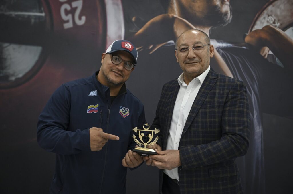 The Turkish Weightlifting Federation President Talat Ünlü (R) presents a plaque to the secretary general of the Venezuelan Weightlifting Federation, Velasquez Noriega Henry Jose, Eryaman, Türkiye, March 26, 2024. (AA Photo)