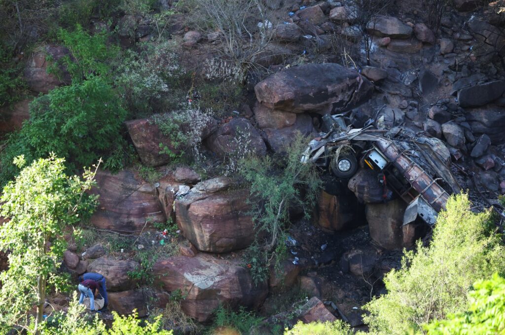 Police officers collect clothing items near the burnt remains of the bus that was taking Easter pilgrims from Botswana to Moria, Limpopo, South Africa, March 29, 2024. (Reuters Photo)