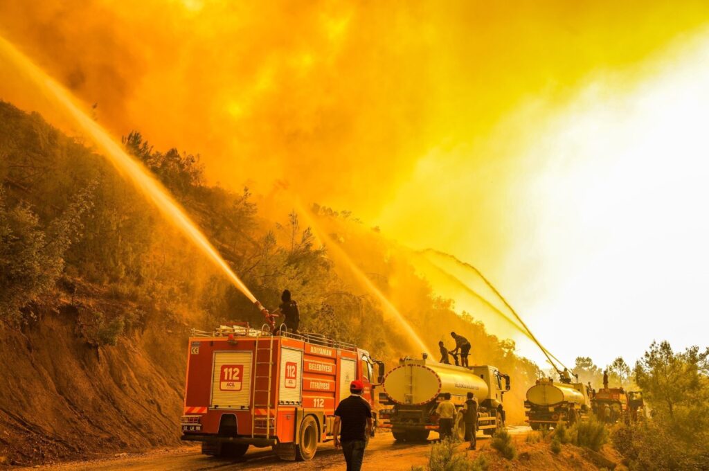 Firefighters spray water on a burning forest, in the Manavgat district, Antalya, southern Türkiye, Aug. 11, 2021. (DHA PHOTO)