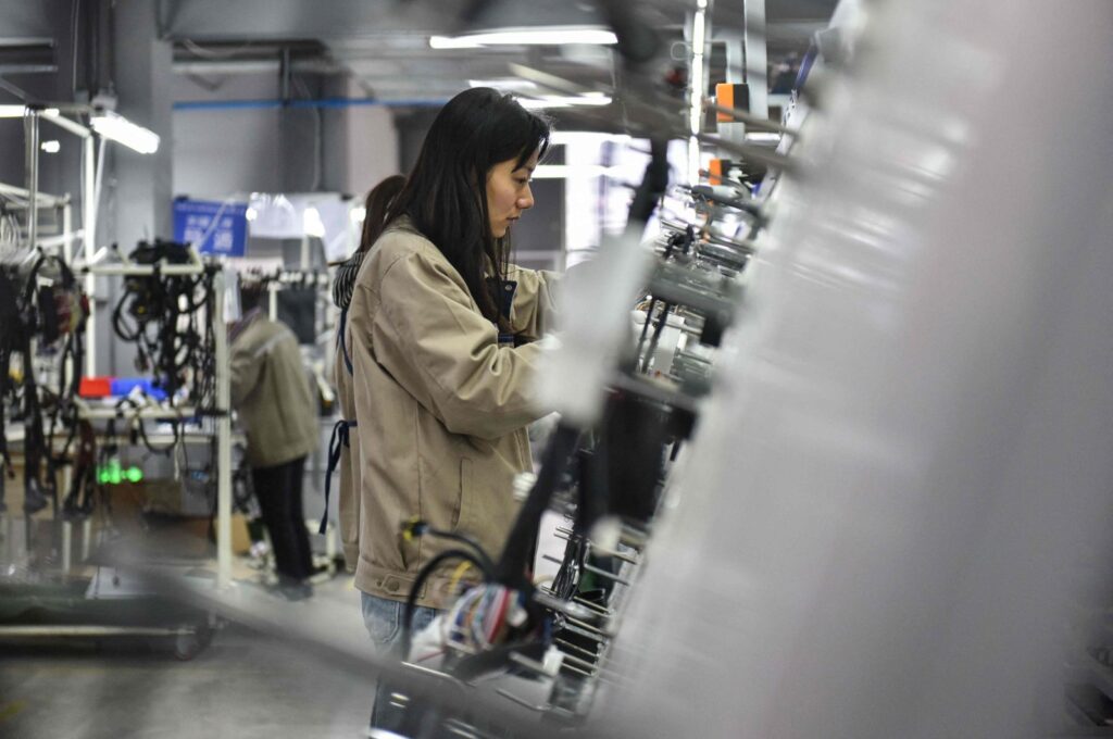 Employees work on a wire harness production line at a factory that supplies car accessories to the automotive market in Fuyang, in eastern China's Anhui province, on March 28, 2024. (AFP Photo)