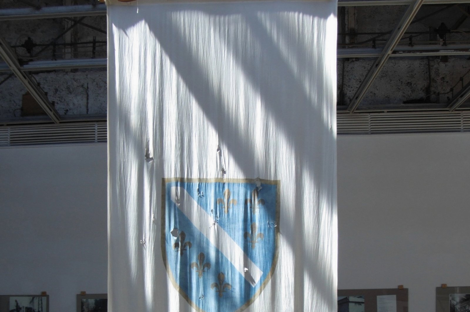 Now displayed in the History Museum, the old Bosnian flag bears the scars of shrapnel, serving as a poignant reminder of the nation's tumultuous past. (Wikipedia Photo)