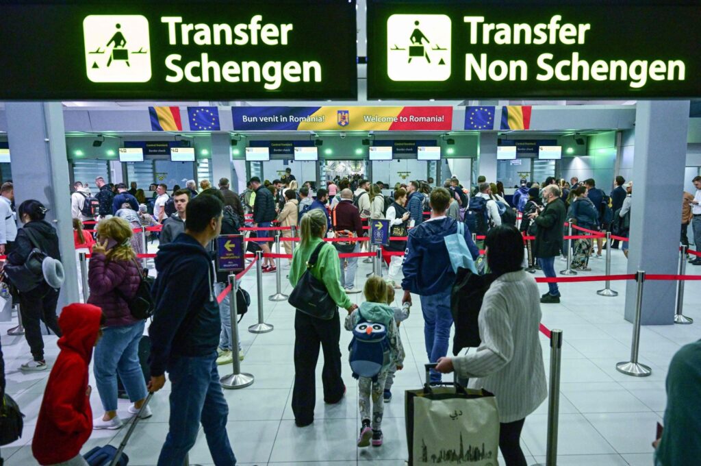 Travelers walk next to newly installed signs pointing to Schengen and non-Schengen areas minutes after midnight, just after Romania's official entry into the European area of free circulation at Otopeni's "Henri Coanda" international airport, Otopeni City, Romania, March 31, 2024. (AFP Photo)