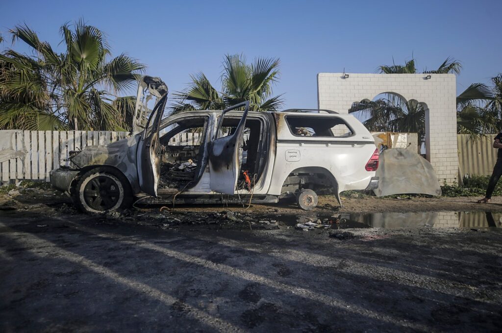 People stand near a destroyed car of the NGO World Central Kitchen (WCK) along Al Rashid road, between Deir Al Balah and Khan Younis in the southern Gaza Strip, April 2, 2024. (EPA Photo)