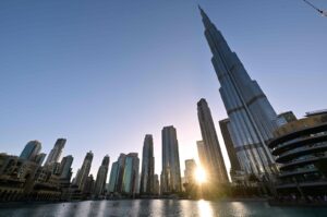 The sun sets behind the Burj Khalifa (R) in the center of Dubai, United Arab Emirates, March 12, 2024. (AFP Photo)