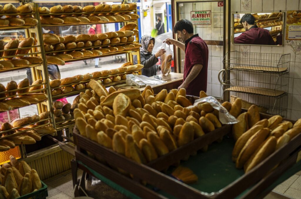 A woman buys bread in a local bakery in the Balat neighborhood of Istanbul, Türkiye, March 19, 2024. (AP Photo)