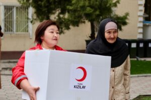A Kyrgyz woman carries humanitarian aid delivered by the Turkish Red Crescent (Kızılay) in Kyrgyzstan, April 8, 2024. (AA Photo)