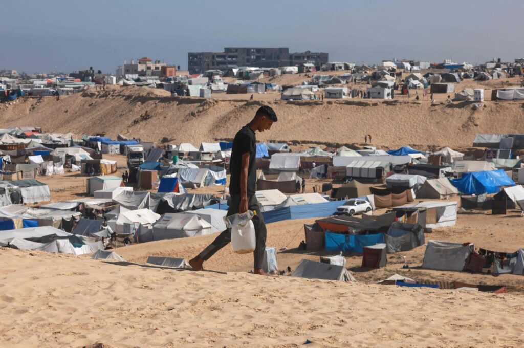 A Palestinian man ferries water at a makeshift camp for displaced people in Rafah in the southern Gaza Strip, Palestine, April 4, 2024. (AFP Photo)