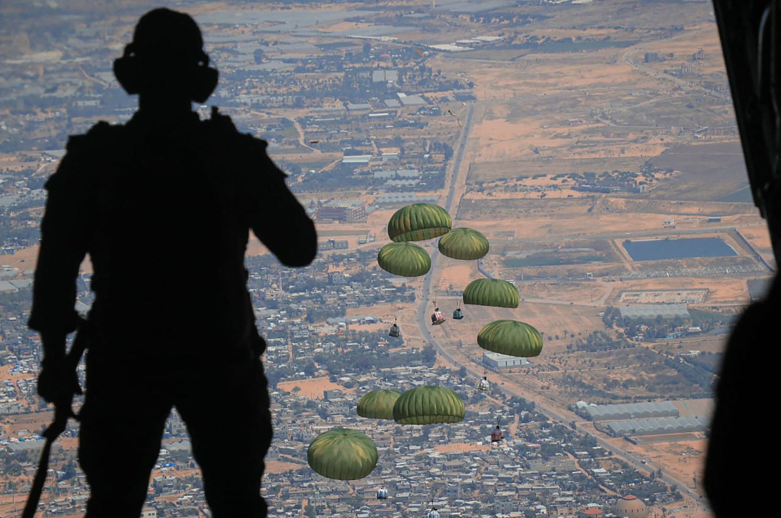 This handout picture released by the Jordanian army on April 9, 2024, shows humanitarian aid being airdropped from a military aircraft over the Gaza Strip amid ongoing strikes by Israel. (AFP Photo)