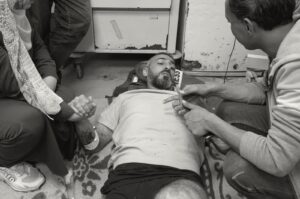 A grayscale picture of Palestinian journalist Sami Shehada (C), wounded in an Israeli strike, lying on the floor at Al-Aqsa Hospital, Deir Al-Balah, Gaza Strip, Palestine, April 12, 2024. (Reuters Photo)