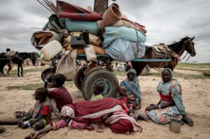 A Sudanese family who fled the conflict in Murnei in Sudan's Darfur region sit beside their belongings while waiting to be registered by UNHCR upon crossing the border between Sudan and Chad, Adre, Chad, July 26, 2023. (Reuters Photo)