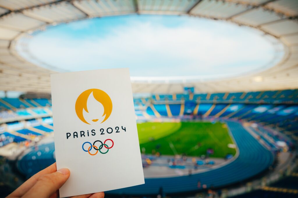 The Paris 2024 Summer Olympic Games emblem is held by a visitor in an empty stadium. (Shutterstock Photo)