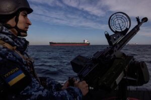 A member of Ukraine's coast guard mans a gun on a patrol boat as a cargo ship passes by in the Black Sea, amid Russia’s attack on Ukraine, Feb. 7, 2024. (Reuters Photo)