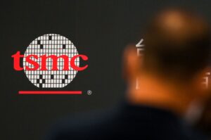 A man walks past a logo of the Taiwan Semiconductor Manufacturing Company (TSMC) during a shareholders' meeting in Hsinchu, June 6, 2023. (AFP Photo)
