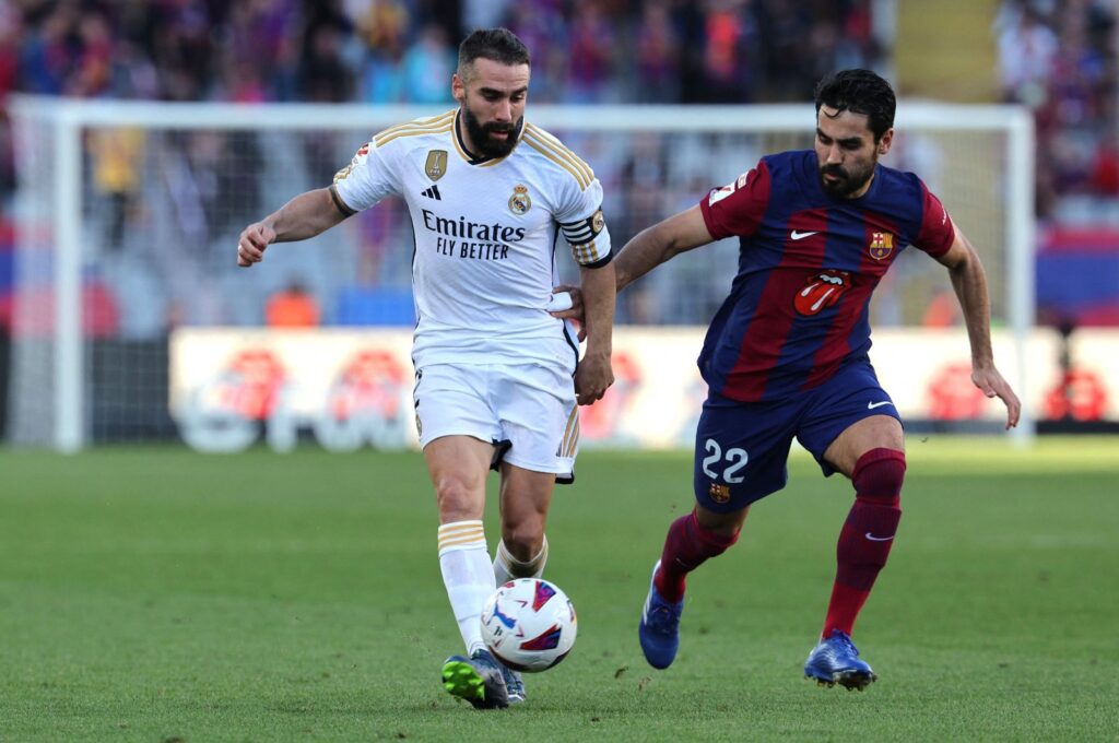 Real Madrid's Dani Carvajal (L) vies with Barcelona's Ilkay Gündoğan during the La Liga match at the Estadi Olimpic Lluis Companys, Barcelona, Spain, Oct. 28, 2023. (AFP Photo)