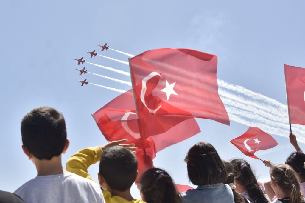 Children waving Turkish flags are watching the air show of the Turkish Stars jet aerobatics team, organized as part of National Sovereignty and Children’s Day celebrations, Konya, central Türkiye, April 21, 2024. (DHA Photo)
