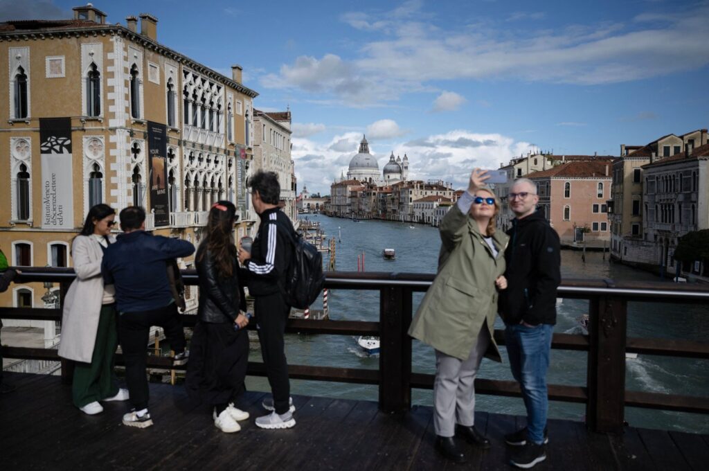 Tourists take selfies with the Grand Canal in the background on the "Ponte dell’Accademia" in Venice, Italy, April 24, 2024. (AFP Photo)