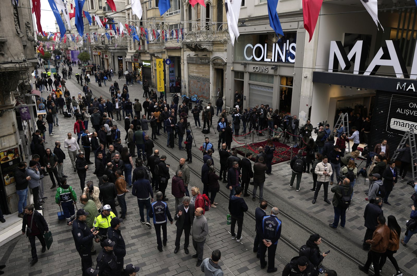 People gather around a memorial placed on the spot of the attack, Istanbul, Türkiye, Nov. 14, 2022. (AP Photo)