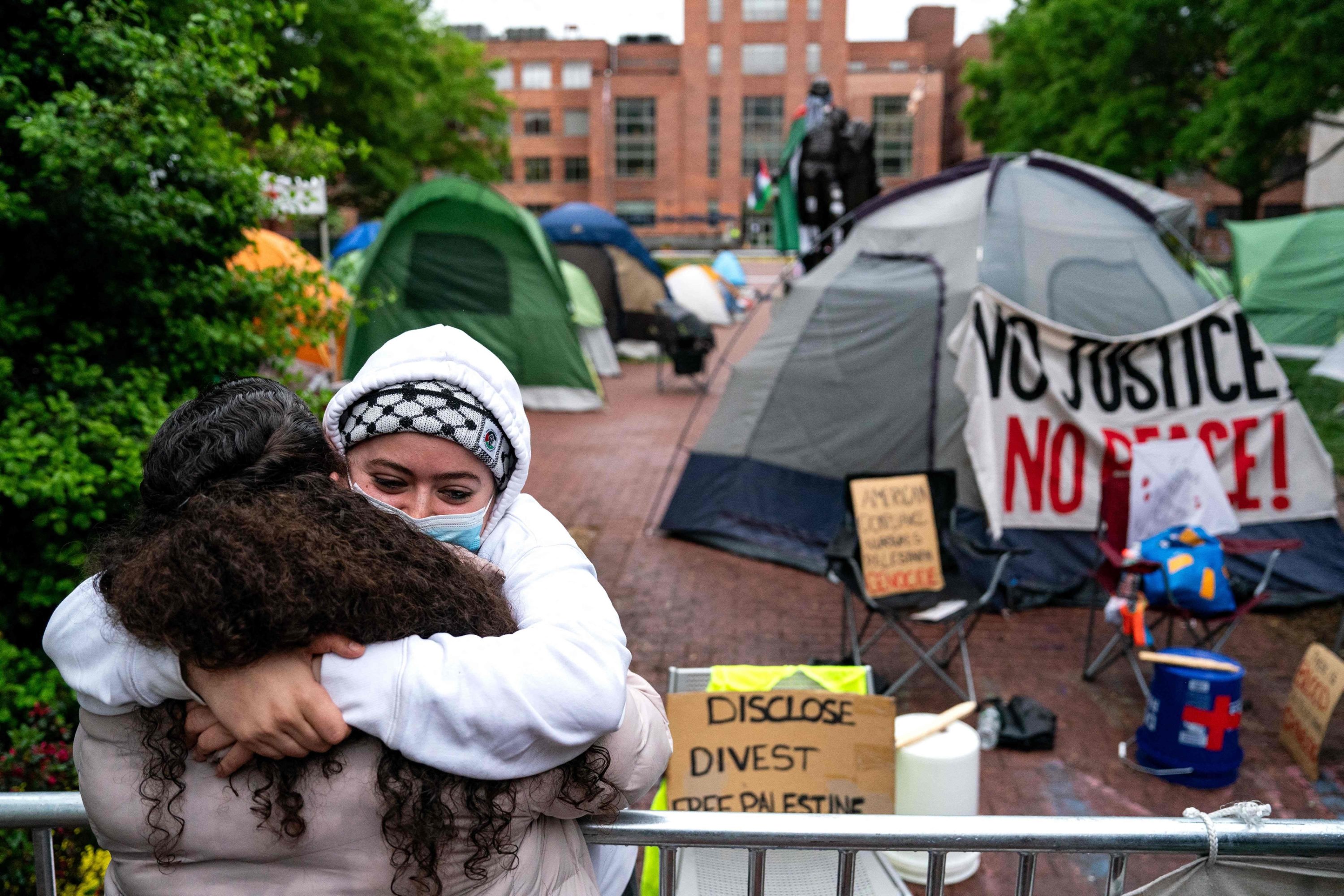 325459 A member of the students activists who are occupying University Yard, hangs someone on the other side of the fencing erected by Campus police as activists and students protest near an encampment at University Yard at George Washington University, in Washington, D.C., April 27, 2024. (AFP Photo)