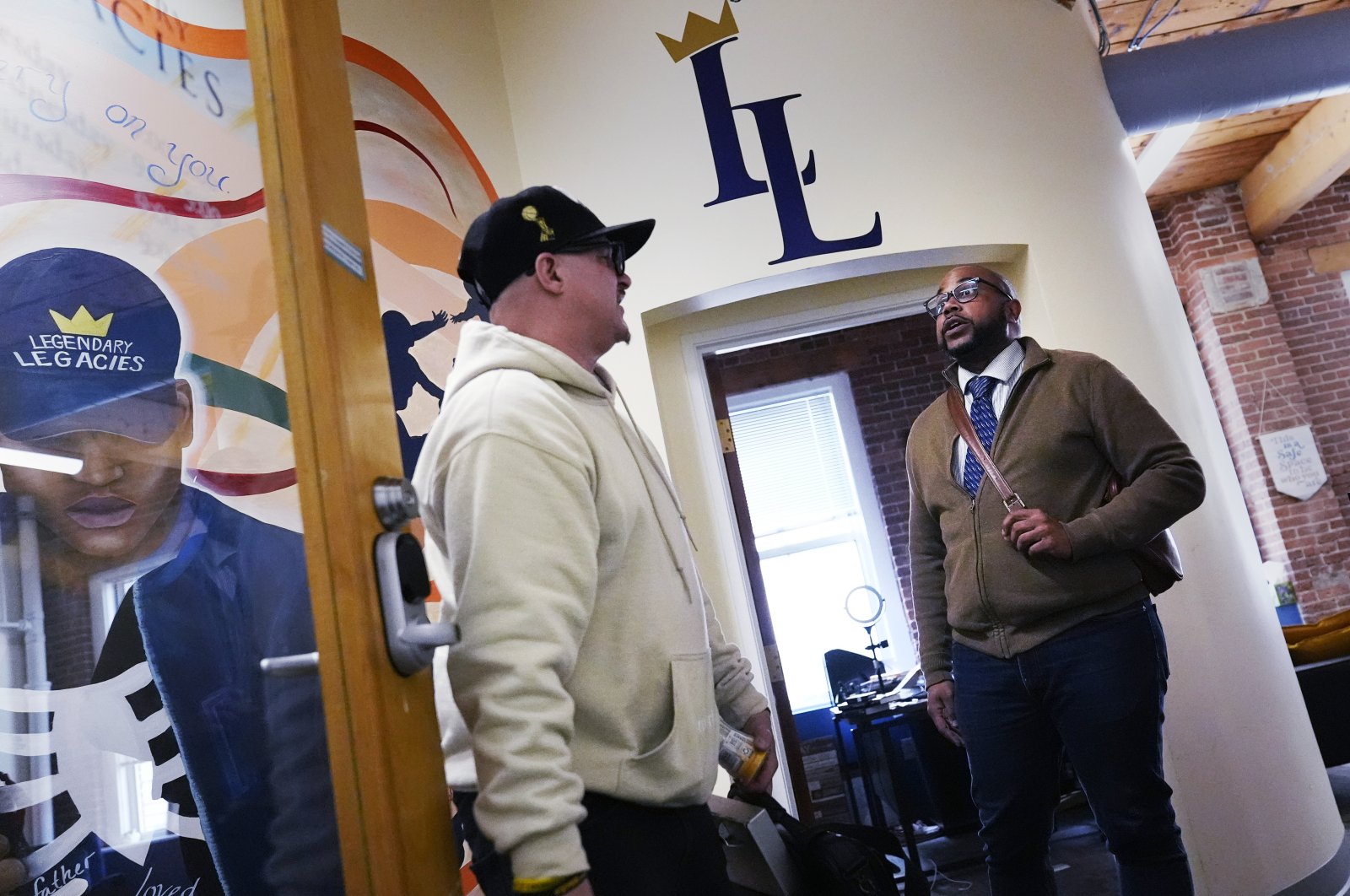 Ron Waddell, founder and executive director of Legendary Legacies, (R) talks with Gary Goyette at the nonprofit organization, Worcester, Mass., U.S., April 19, 2024. (AP Photo)