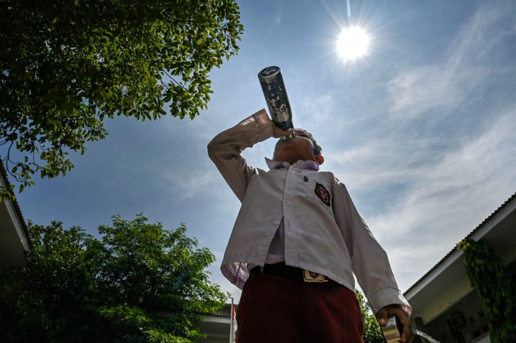A student drinks water while studying outside the classroom during a heatwave in Banda Aceh, Indonesia, May 7, 2024. (AFP Photo)