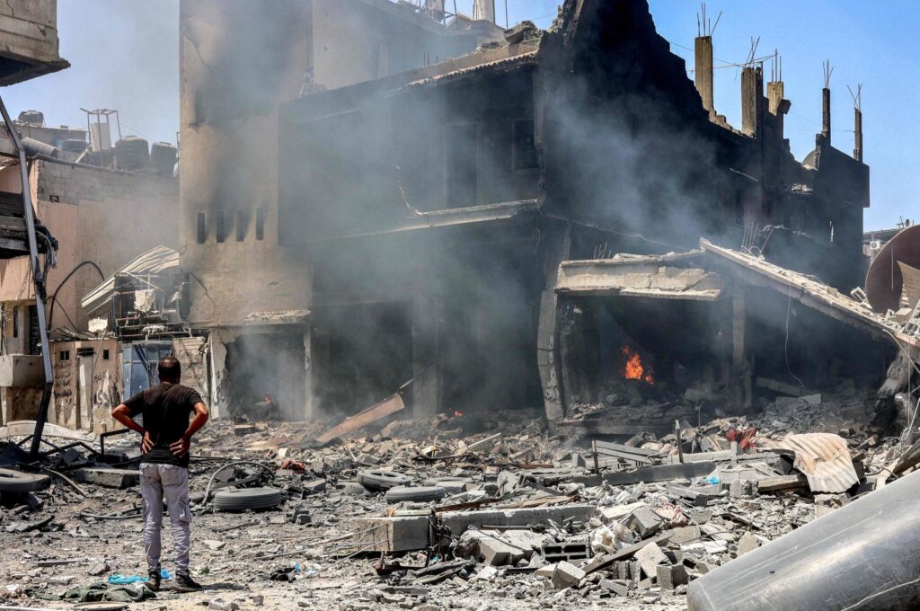 A man stands before a charred building that is still on fire in the Zaytoun neighborhood of Gaza City, Palestine, May 9, 2024. (AFP Photo)