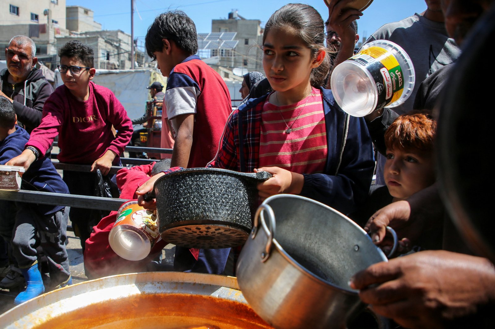 Palestinians gather to receive food cooked by a charity kitchen, amid shortages of aid supplies, after Israeli forces launched a ground and air operation in the eastern part of Rafah, as the ongoing conflict between Israel and Hamas continues, in Rafah, southern Gaza Strip, Palestine, May 8, 2024. (Reuters Photo)