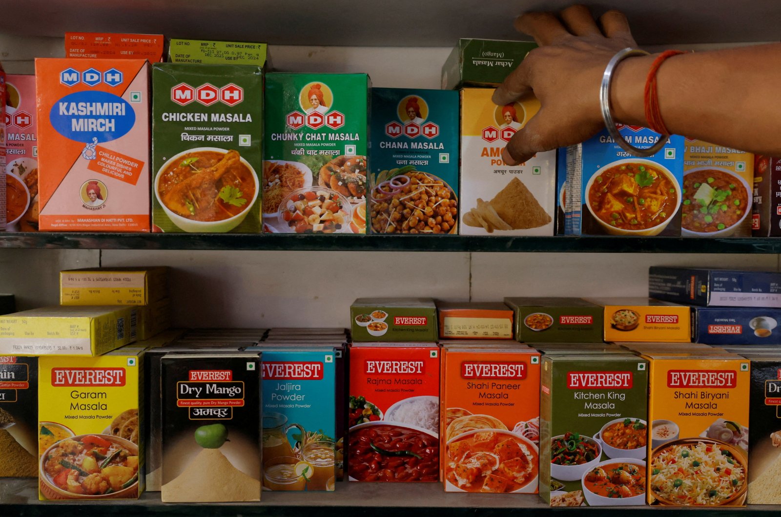 A man adjusts the spice boxes of MDH and Everest on the shelf of a shop at a market in New Delhi, India, April 29, 2024. (Reuters Photo)