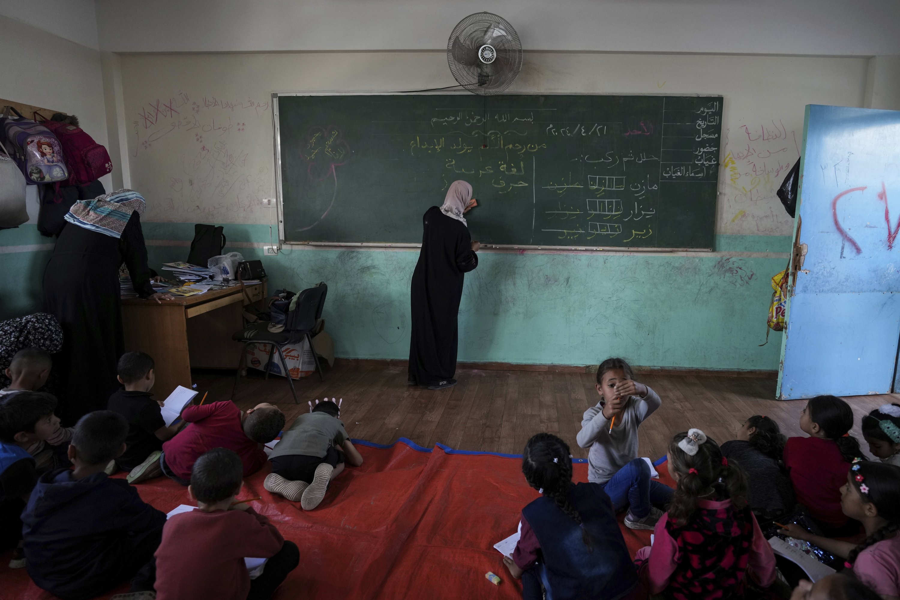 328373 Manal al-Buhaisi works with children at a makeshift class, Deir al-Balah, Palestine, April 20, 2024. (AP Photo)