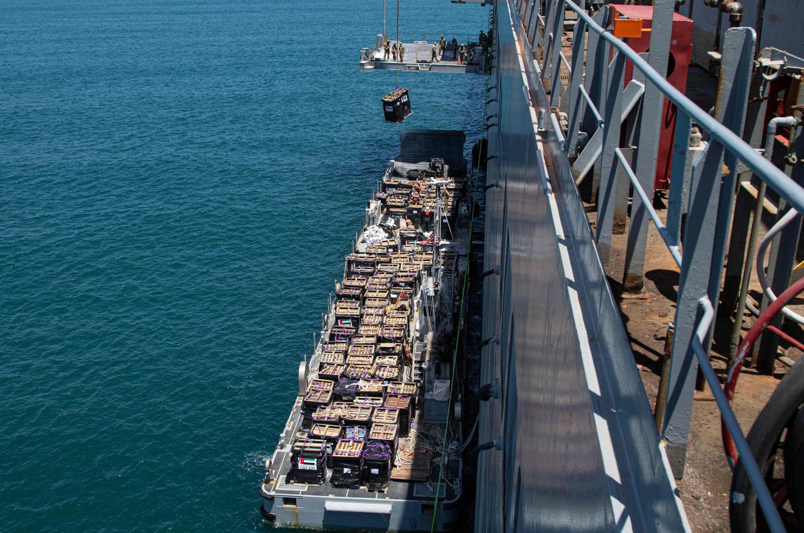 A humanitarian aid shipment is lifted by a crane operated by soldiers assigned to the 7th Transportation Brigade (Expeditionary) from a naval causeway at the Port of Ashdod, Israel, May 16, 2024. (AFP Photo)