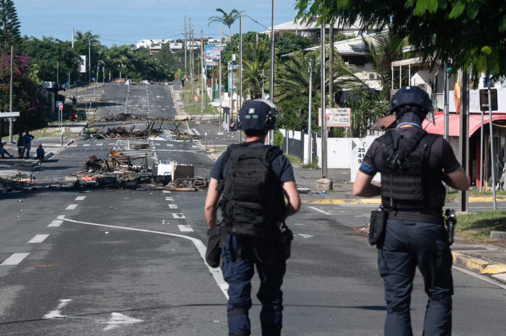 Police patrol a street blocked by debris and burnt-out items following overnight unrest in the Magenta district of Noumea, France's Pacific territory of New Caledonia, May 18, 2024. (AFP Photo)