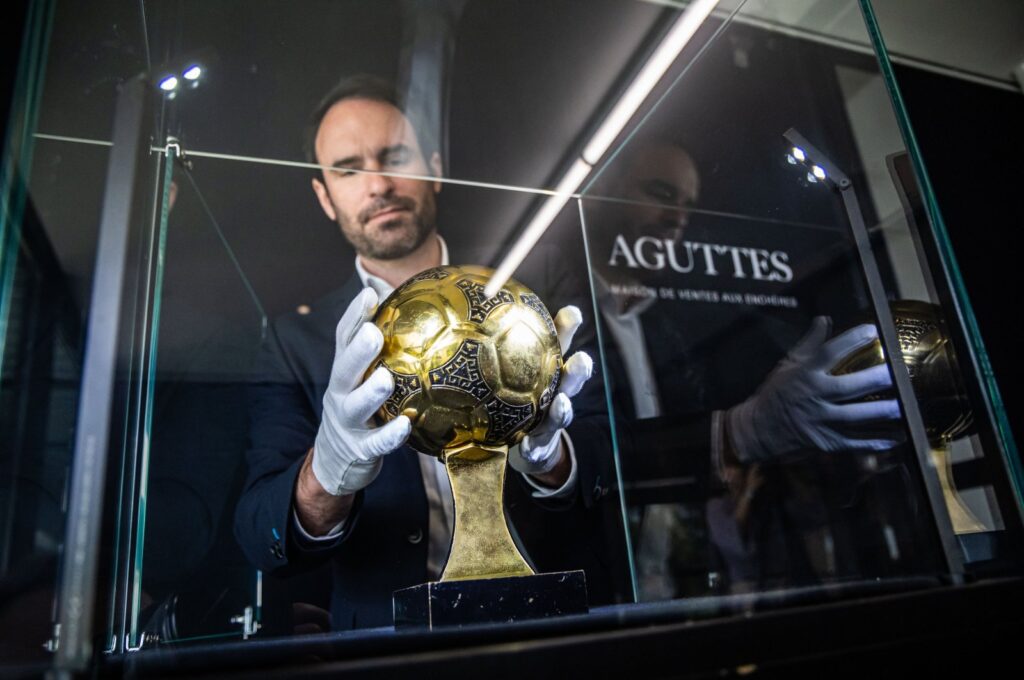 Francois Thierry, the sports expert at Aguttes auction house, installs the Diego Maradona's Golden Ball trophy in the case display, the trophy awarded to best player of the 1986 Football World Cup in Neuilly, Paris, France, May 13, 2024. (EPA Photo)
