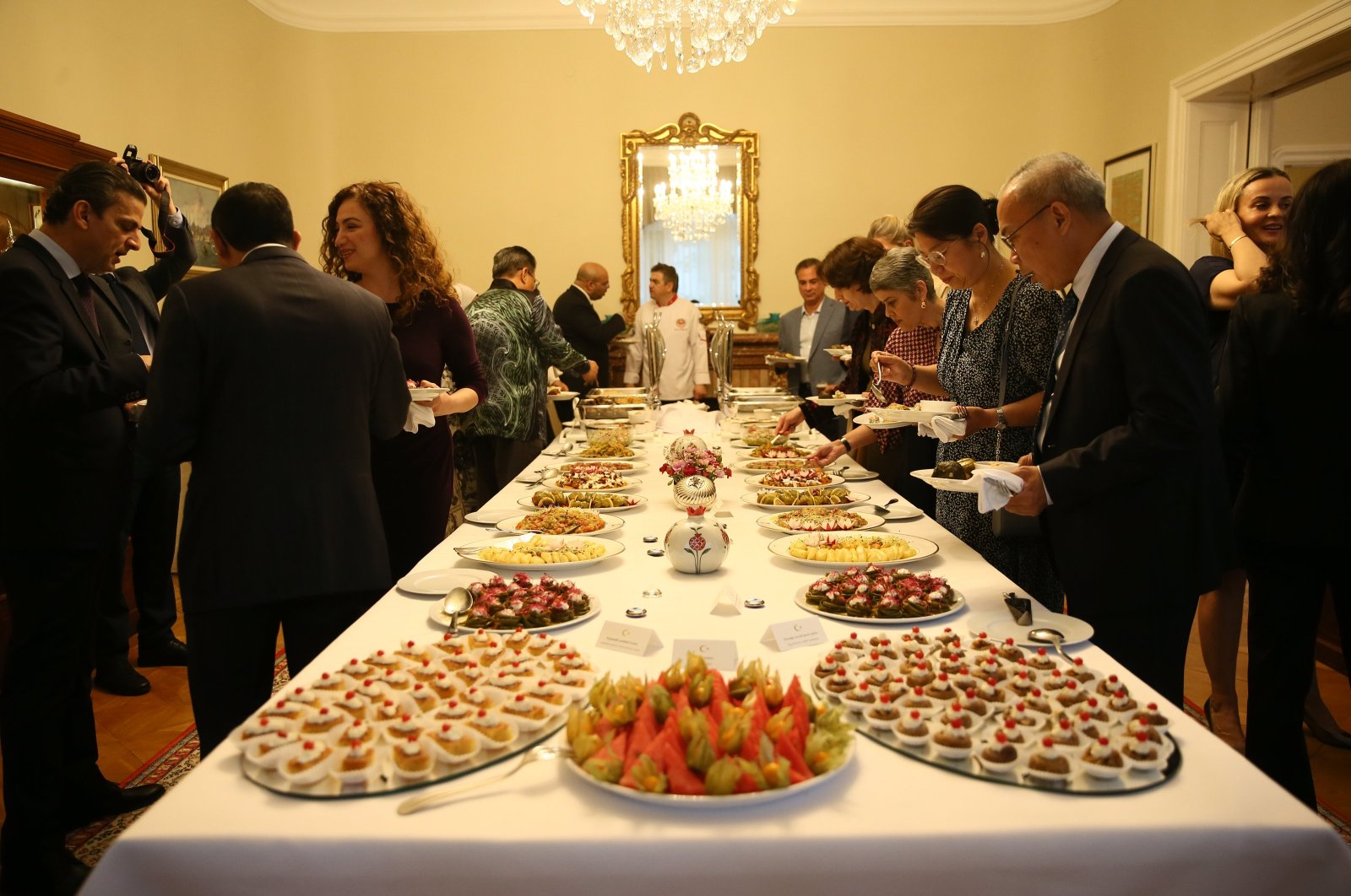 Ambassador Levent Eler (L), Türkiye's permanent representative to the United Nations office in Vienna, and his wife, Ayten Eler, present tastes from the Aegean region, Vienna, Austria, May 24, 2024. (AA Photo)