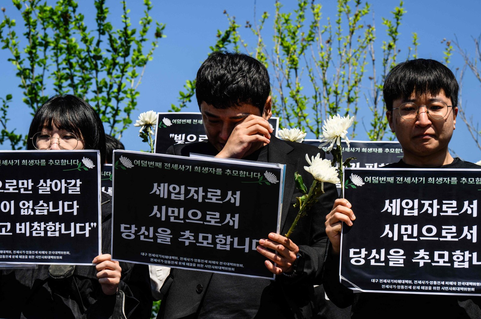"Jeonse" real estate scam victims react at a rally near the National Assembly, during which signs were held that translate as "I pay tribute to you as a tenant and as a citizen," in tribute to the latest scam victim who killed themself, in Seoul, South Korea, May 8, 2024. (AFP Photo)