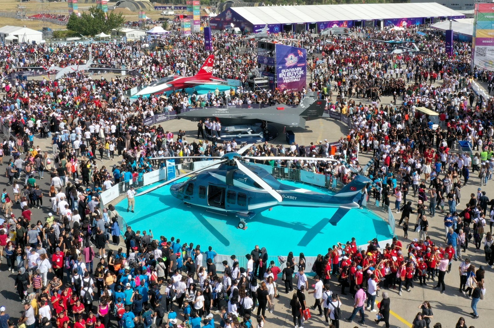 Crowds of visitors surround a Gökbey helicopter and a Kızılelma unmanned fighter jet during the edition of Teknofest held in Izmir, western Türkiye, Sept. 28, 2023. (AA Photo)