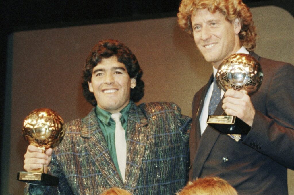 Argentina's Diego Maradona (L) and West German goalkeeper Harald Schumacher hold their World Cup Ball awards while posing with two young players during the Soccer Golden Shoe Award ceremony, Paris, France, Nov. 13, 1986. (AP Photo)