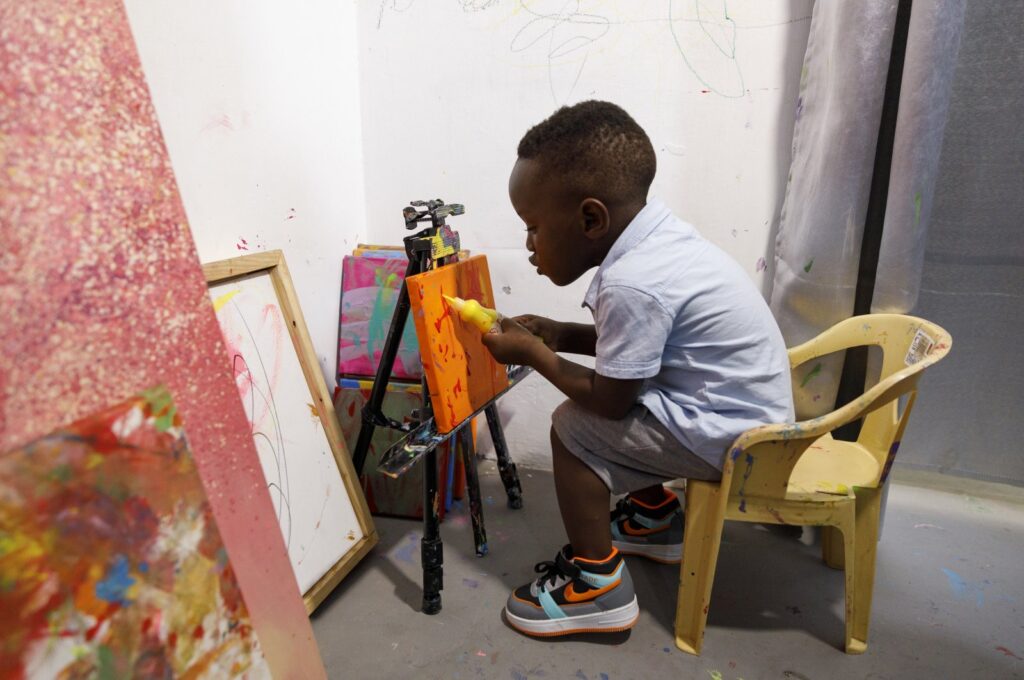 Ace-Liam Nana Sam Ankrah, who will turn 2 in July, paints at his mother's art gallery in Accra, Ghana, May 27, 2024. (AP Photo)