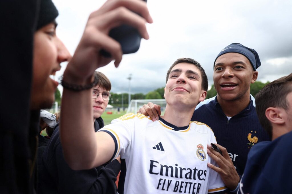 France's Kylian Mbappe (R) poses for a selfie photograph with a fan wearing a Real Madrid jersey, ahead of a training session, as part of the team's preparation for the upcoming UEFA Euro 2024 Football Championship, Clairefontaine-en-Yvelines, Paris, France, May 30, 2024. (AFP Photo)