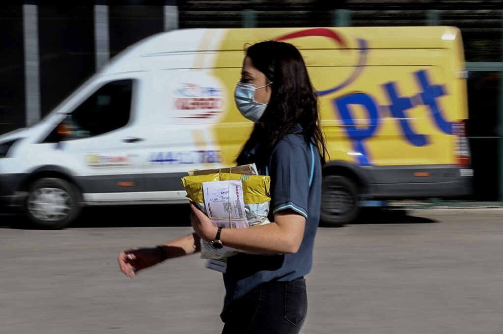 A PTT employee walks in front of a postal service vehicle in Turkish capital Ankara's Yenimahalle district, Ankara, Türkiye, Oct. 9, 2021. (AA Photo)