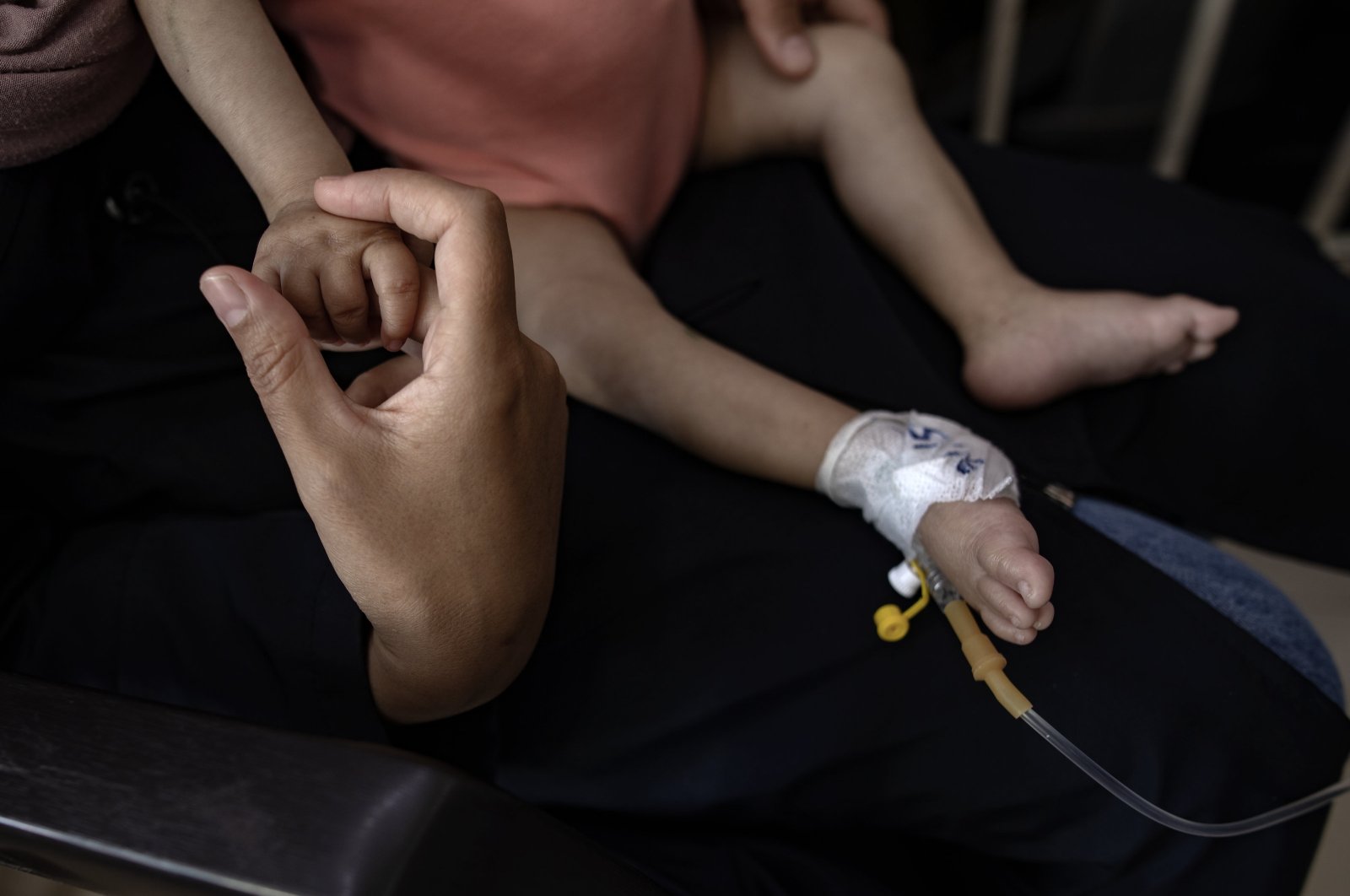 Palestinian child Yousef al-Jojo sits on his mother's lap as she holds his hand at Al-Aqsa Martyrs Hospital in Deir al-Balah, Gaza Strip, June 1, 2024. (EPA Photo)