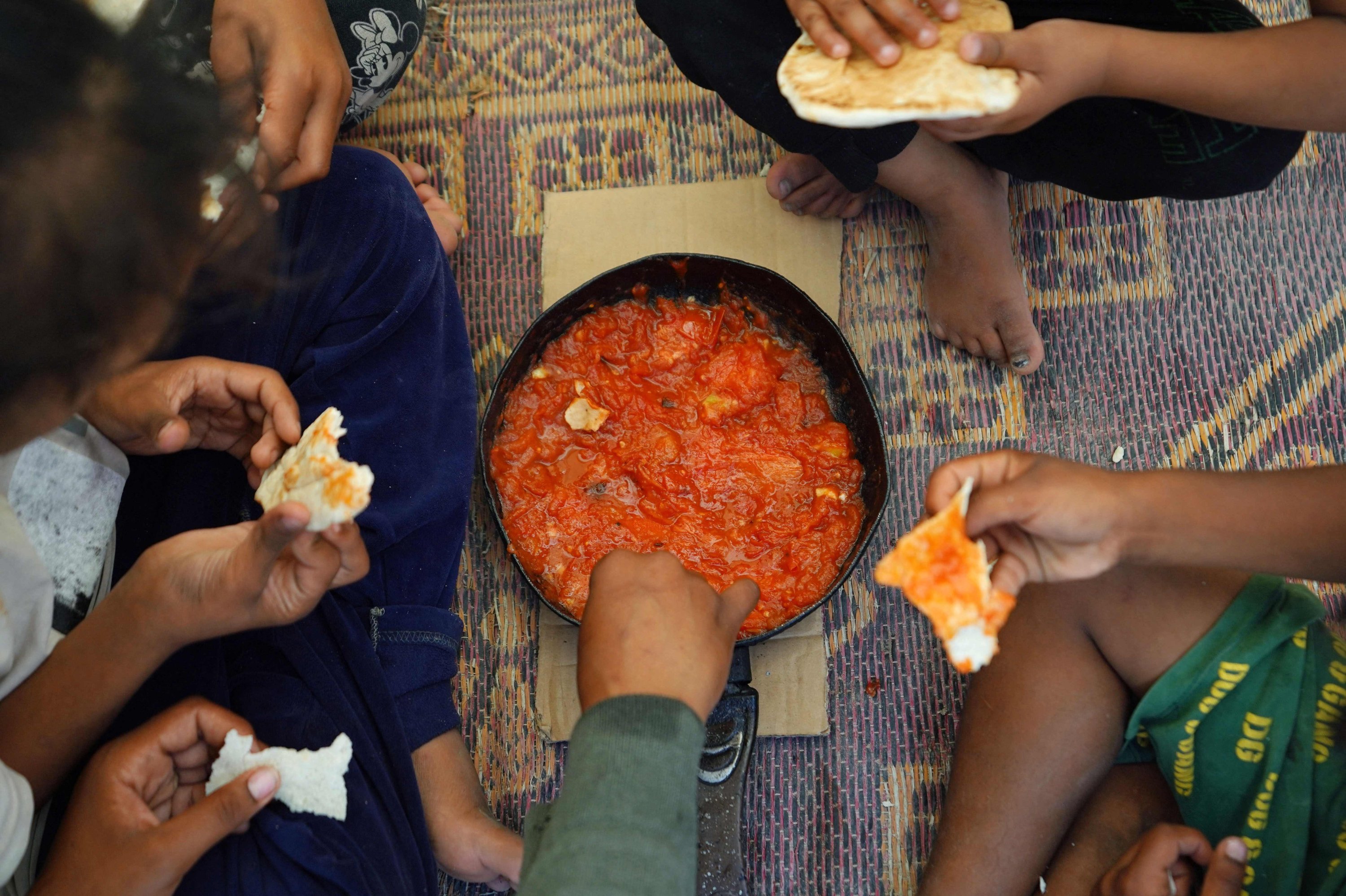 330932 Palestinian children share a meal inside a tent for displaced people in Deir al-Balah in the central Gaza Strip, Palestine, May 30, 2024. (AFP Photo)