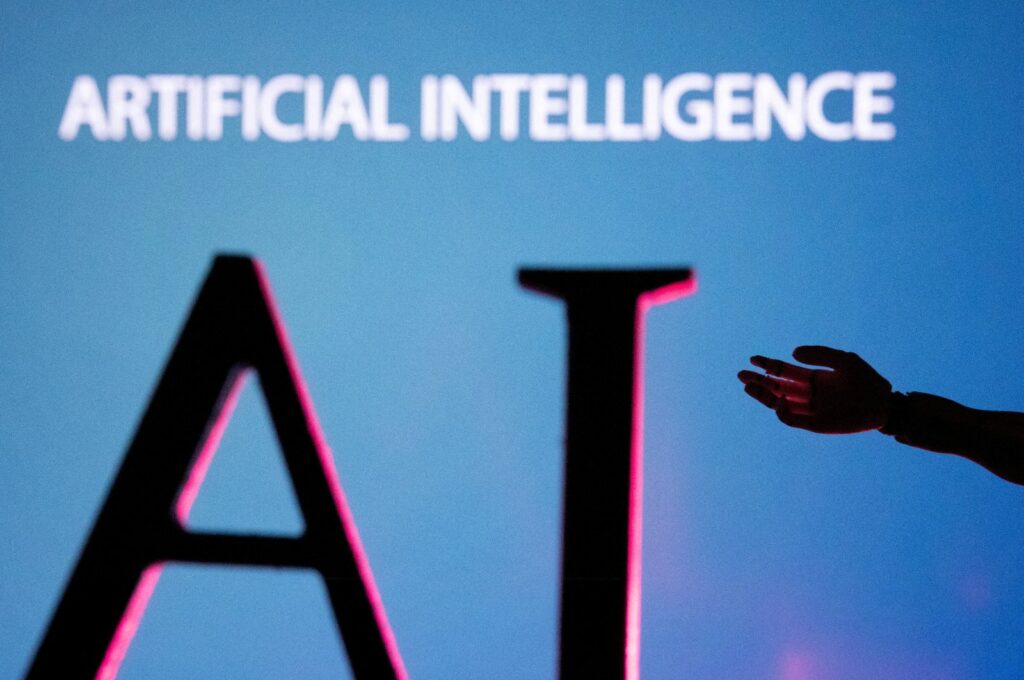 AI letters and robot hand miniature are seen in this illustration taken on June 23, 2023. (Reuters Photo)