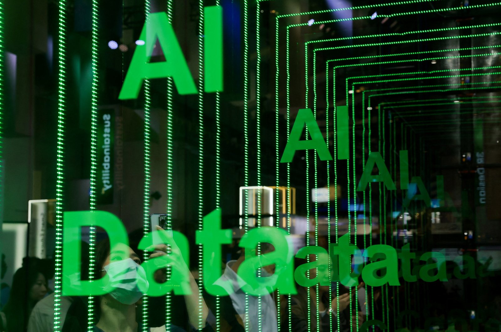 A person takes a photo of an AI data sign at Computex in Taipei, Taiwan, June 5, 2024. (Reuters Photo)