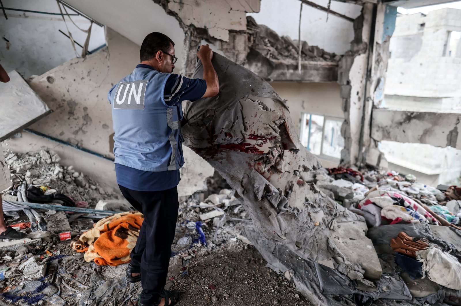 A UNRWA official looks at the damage caused by the Israeli attack that killed 39 in Nuseirat, central Gaza, Palestine, June 6, 2024. (AA Photo)