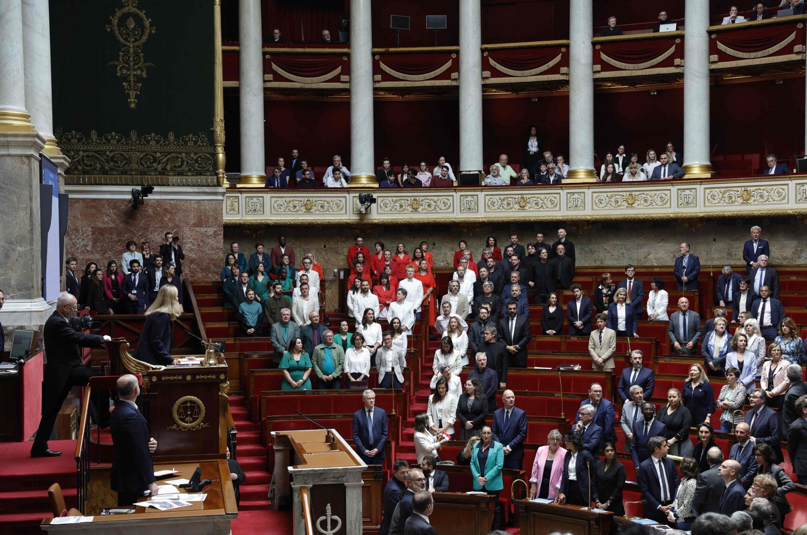 French members of Parliament stand during a session of questions to the government at the National Assembly, after French Member of Parliament of "La France Insoumise" (LFI) group Rachel Keke waved a Palestinian flag in the Assembly Chamber in Paris on June 4, 2024. (AFP Photo)