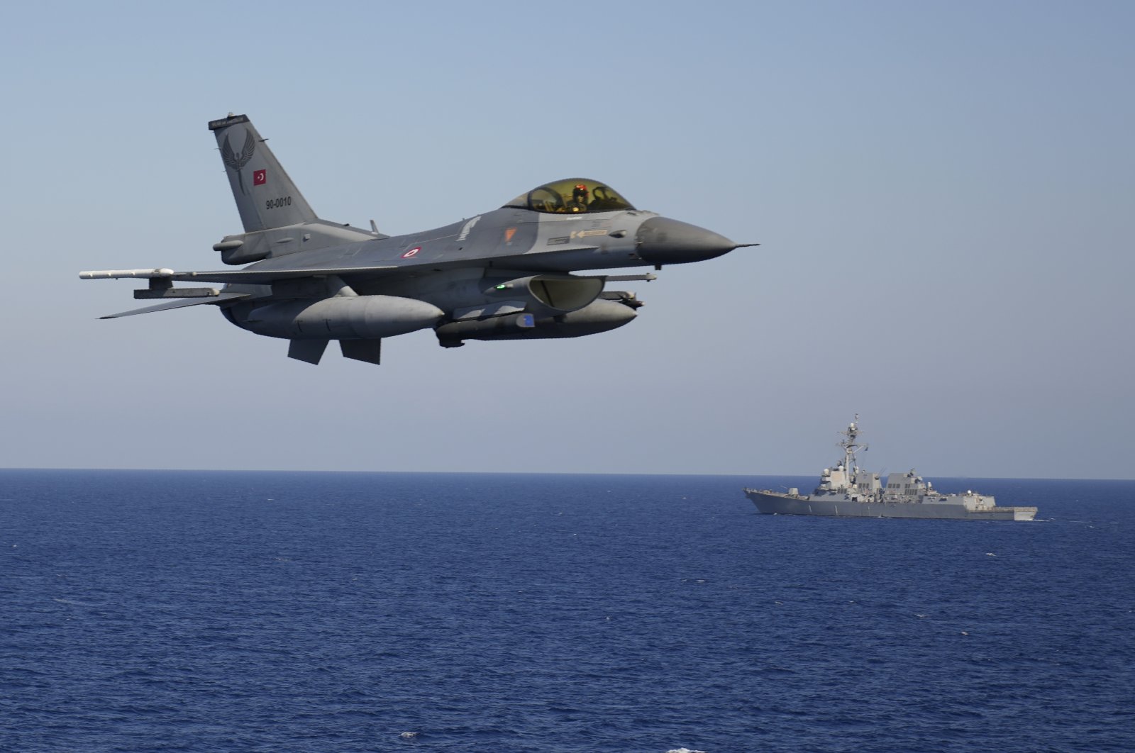 A Turkish F16 fighting jet flies over naval ships during an annual NATO naval exercise on Türkiye's western coast on the Mediterranean, Sept. 15, 2022. (AP Photo)