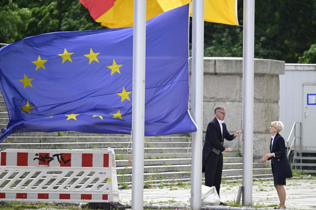 Bundestag employees hoist the European and the German flags, in front of the Reichstag building housing the Bundestag (lower house of parliament) in Berlin, Germany, June 11, 2024. (AFP Photo)