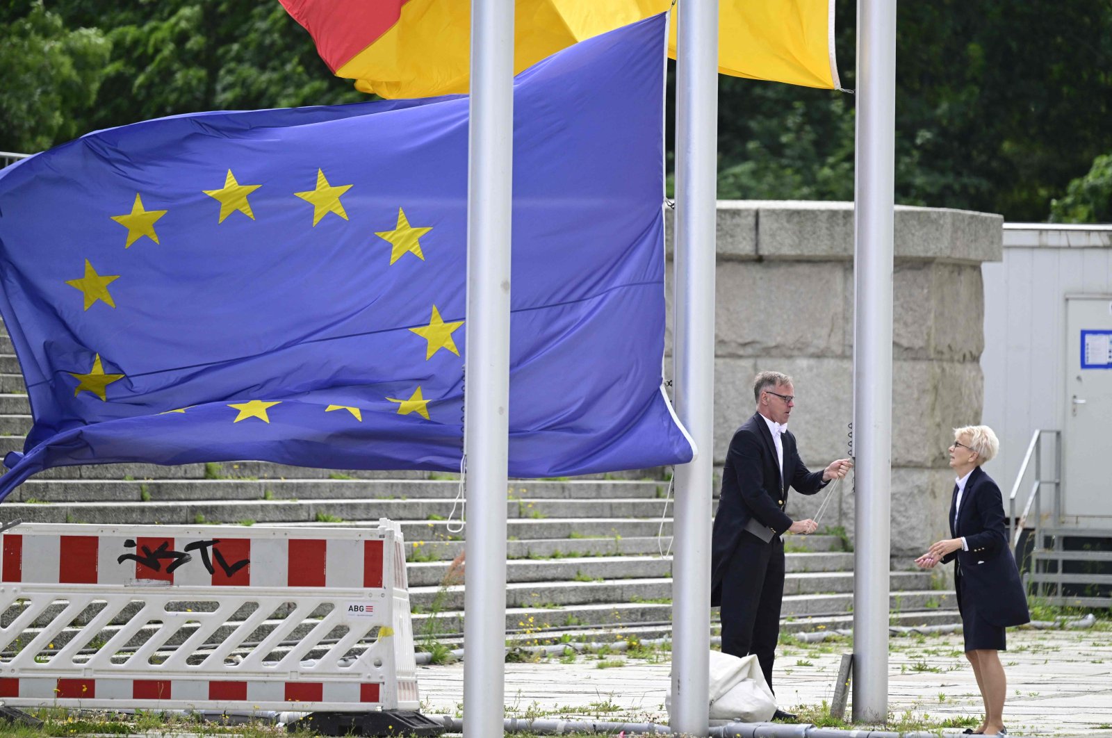 Bundestag employees hoist the European and the German flags, in front of the Reichstag building housing the Bundestag (lower house of parliament) in Berlin, Germany, June 11, 2024. (AFP Photo)